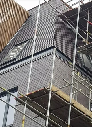 A building under construction featuring a grey brick exterior
